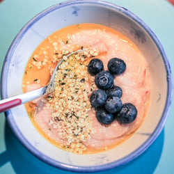 Raspberry porridge with hemp seeds and blueberries with linseed oil.