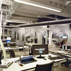 Arbeitsatmosphäre durch sichtbare Kabelstränge und Rohrleitungen.