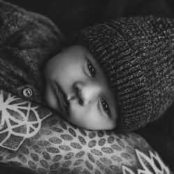 Baby auf tätowiertem Arm in schwarz weiß