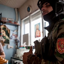 a kurdish special forces soldier in a christian shop in Quaraqosh/Iraq