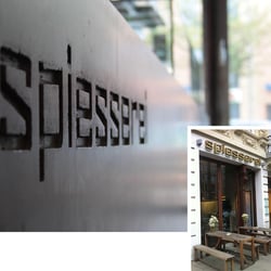 Eingelassenes Logo am Tresen und in goldenen hinterleuchteten Lettern an der Fassade