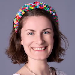 business-headshot-frau-natuerlich-laechelnd-grauer-hintergrund