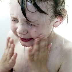 Kind das sich in einer Badewanne wäscht