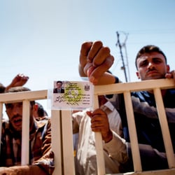 refugee holding a ID and waiting for relief items