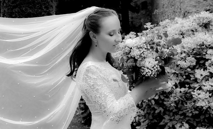 Brautfotos mit wehendem Brautschleider und wunderschönen Blumen