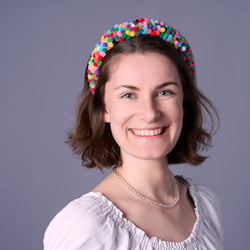 business-headshot-frau-natuerlich-laechelnd-grauer-hintergrund
