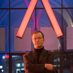 Opernintendant Dr. Michael Klügl. Im Hintergrund das Logo der Staatsoper Hannover