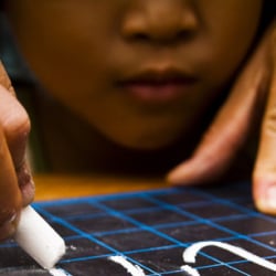 A young girl learning to write Vietnamese at a children’s shelter in Saigon, Vietnam.