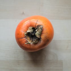 Persimmon fruit on wooden background.