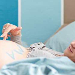 Finger auf dem Babybauch