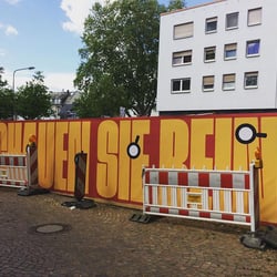 Gestaltung des Bauzauns am Ettinghausenplatz, Frankfurt-Höchst, Ansicht des Banners der Südseite (Gucklöcher werden noch ausges