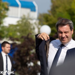 Markus Soeder steigt aus dem Auto und zieht sich sein Jacket an.