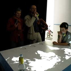 Das WORLDATER Interaktionspult in Benutzung – ein Besucher trinkt aus der WORLDWATER-Flasche