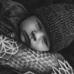 Baby auf tätowiertem Arm in schwarz weiß
