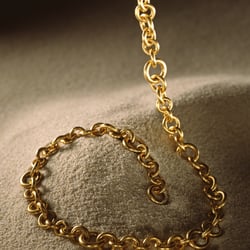 Goldkette auf Sand
