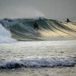 Surfen bei Sonnenuntergang in Uluwatu, Bali