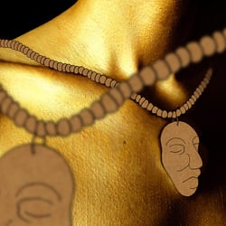 Ein golden angemaltes Model wird mit Kraftpapier-Schmuck verziert