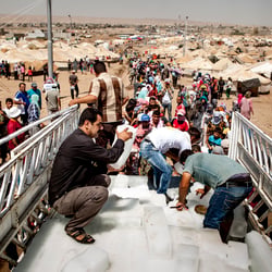 hand-out of ice cubes in a refugee camp