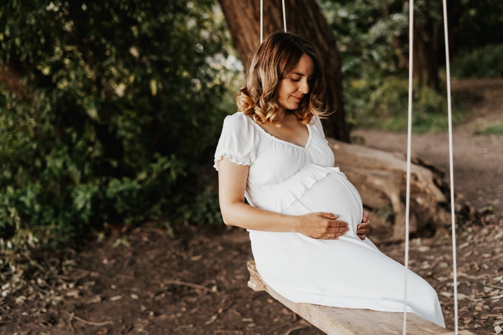 Schwangere Frau beim Babybauchshooting in der Natur an der Elbe in Dresden