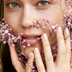 Beautyaufnahme mit floralen Elementen und natürlicher, frischer Ausstrahlung.
